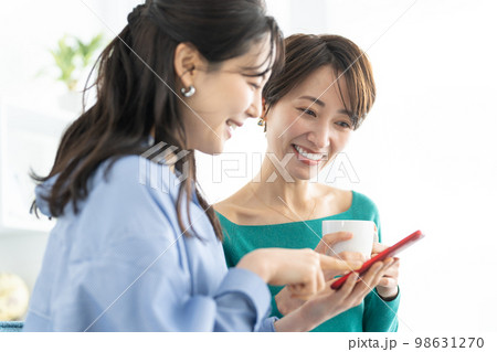 スマホを友達に見せる女性 スマホを友達に見せる女性 98631270