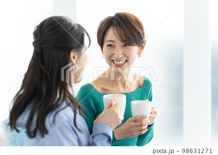 部屋で会話する笑顔の女性 部屋で会話する笑顔の女性 98631271