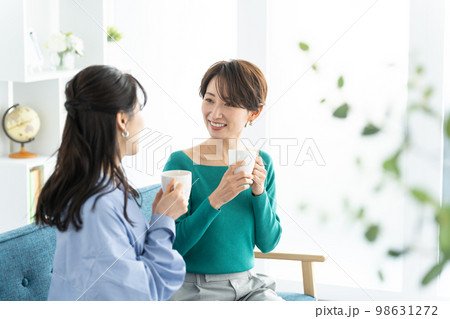 部屋で会話する笑顔の女性 部屋で会話する笑顔の女性 98631272