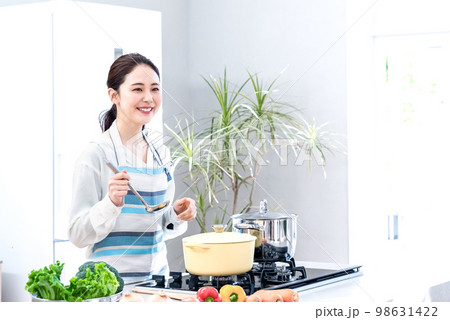 新築一軒家のキッチンで料理をする主婦 98631422