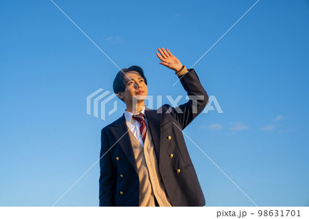 制服を着た男子高校生のポートレート　青空　空　屋外　河川敷　韓国人　カーディガン　学生服 98631701