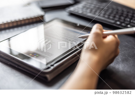 Woman working with digital tablet and pen, checking document, contract or agreement - Close up Woman working with digital tablet and pen, checking document, contract or agreement - Close up 98632582