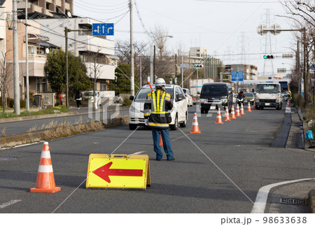 道路工事のため車を誘導する交通誘導員 道路工事のため車を誘導する交通誘導員 98633638