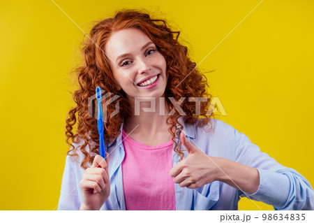 woman redhaired ginger with eco toothbrush and toothpaste on yellow studio background 98634835