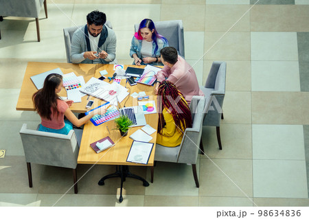 mixed-race journalist fashion designers working together in a bright office 98634836