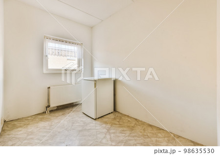 an empty room with white walls and marble flooring on the right, there is a small radiag in the corner 98635530