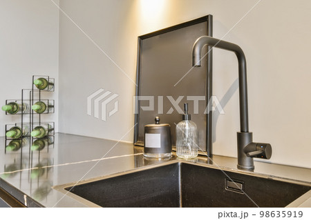 a kitchen sink with green apples on the countertop in front of it and an open door to the bathroom behind 98635919