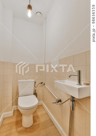 a bathroom with a toilet, sink and mirror on the wall next to it is a light fixture in the ceiling a bathroom with a toilet, sink and mirror on the wall next to it is a light fixture in the ceiling 98636559