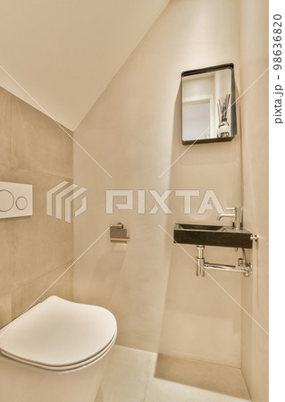 a bathroom with a toilet and mirror on the wall next to it is an image of a man's reflection 98636820