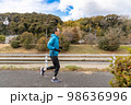川沿いの遊歩道で趣味のジョギングをしている一人の中高年男性 98636996