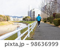 川沿いの遊歩道で趣味のジョギングをしている一人の中高年男性 98636999