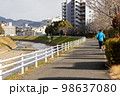 川沿いの遊歩道で趣味のジョギングをする一人の中高年男性 98637080