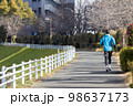 川沿いの遊歩道で趣味のジョギングをする一人の中高年男性 98637173