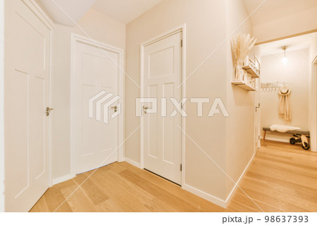 an empty room with wooden floors and white doors in the middle part of the room there is a mirror on the wall 98637393