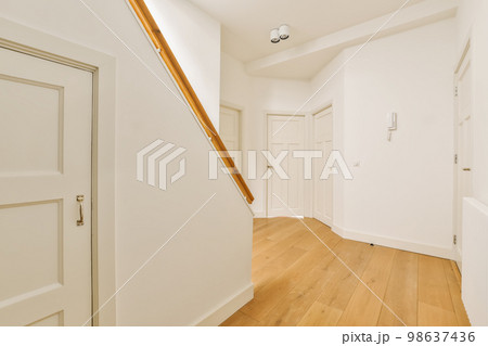 an empty room with white walls and wood flooring the door is in front of the wall to the right an empty room with white walls and wood flooring the door is in front of the wall to the right 98637436
