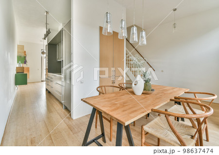 Interior of the dining area next to the stairs to the top and a vase of flowers on the table 98637474