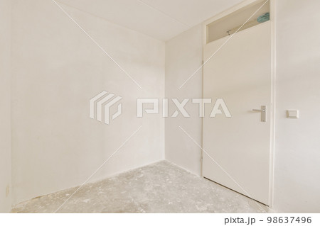 an empty room with white walls and no one door on the other wall there is a small window in the corner 98637496