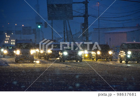 雪が降る夜の道路 98637681