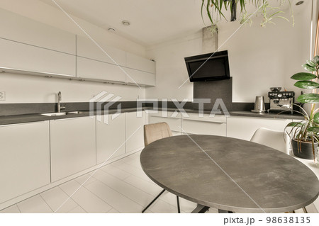 a small kitchen with white cabinets and black counter tops on the counters in this photo is taken from the inside 98638135