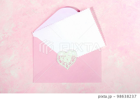 Pink envelope with lace heart and empty white blank sheet for text on pink. Top view. Close up. 98638237