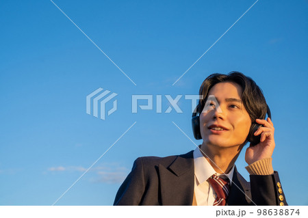 ヘッドフォンで音楽を聴く高校生　英語　リスニング　制服　ブレザー　青空　サブスク 98638874
