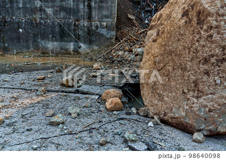 A huge rock fell from the mountains onto the road, destroying the asphalt and blocking half of the roadway 98640098