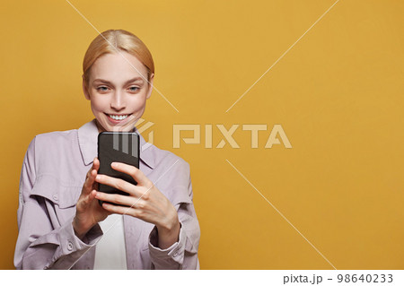 Young pretty woman using app or sending a message with the mobile phone Young pretty woman using app or sending a message with the mobile phone 98640233