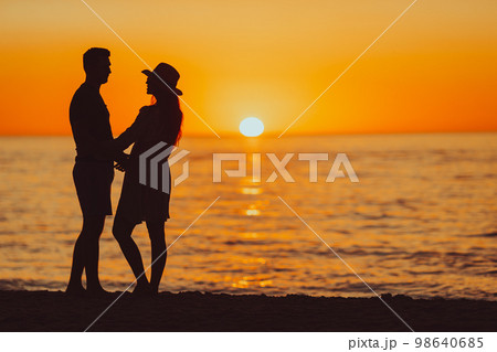 Young couple on white beach during summer vacation at sunset. PHOTO OUT OF FOCUS 98640685
