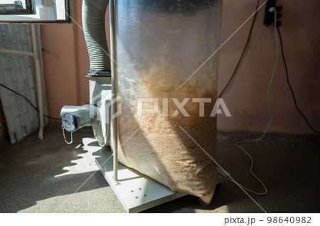 Vacuuming sawdust while sawing wood. Chip blower in furniture production.  98640982