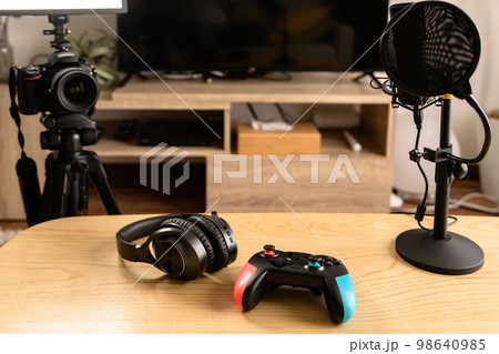 ゲーム配信する機材を並べる　一眼レフとマイクとコントローラーヘッドホン　ゲーム実況　ユーチューバー 98640985
