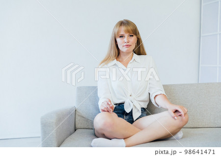 a woman in home style relaxes on the sofa at home 98641471