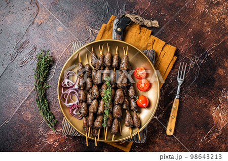 Grilled chicken heart on skewers on a steel plate. Dark background. Top view 98643213