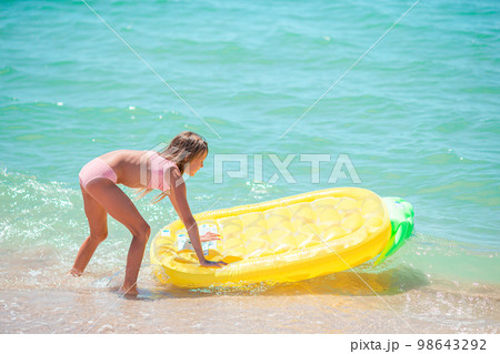 Little happy girl with inflatable air mattress in the sea having fun Little happy girl with inflatable air mattress in the sea having fun 98643292