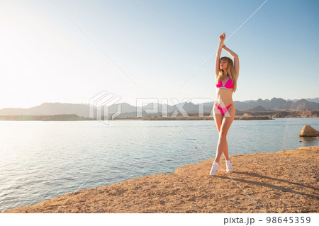 Charming young woman wearing a swimsuit Charming young woman wearing a swimsuit 98645359