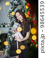 Happy brunette with gifts in hands 98645539