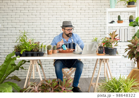 An elderly man handsome with have mustache wearing glasses is happy with tree care. is a hobby of gardening at home, living happily after retirement. Concepts nature and environment 98648322