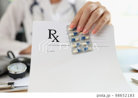 Female doctor shows blank prescription paper and medical pills. 98652183