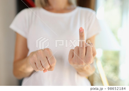 Woman showing fist and middle finger as fuck gesture. Woman showing fist and middle finger as fuck gesture. 98652184