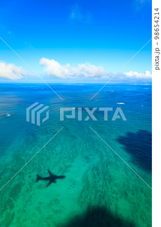 沖縄の海に映る飛行機の影の風景 98654214