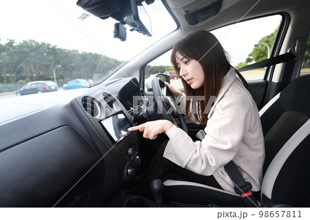 運転中にカーナビを使う若い女性 運転中にカーナビを使う若い女性 98657811