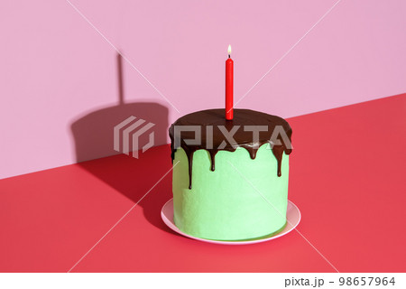 Birthday cake with a lit candle. Homemade cake with peppermint and chocolate. 98657964