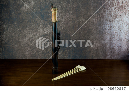 Small Blowpipe and Darts Made by the Dayak People of Sarawak in Borneo on an Old Varnished Table Top Small Blowpipe and Darts Made by the Dayak People of Sarawak in Borneo on an Old Varnished Table Top 98660817