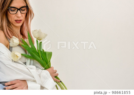 Bouquet of white tulips in a female hand on a white background. Bouquet of white tulips in a female hand on a white background. 98661855