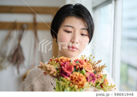 花束を持つ若い女性のポートレート 98661948