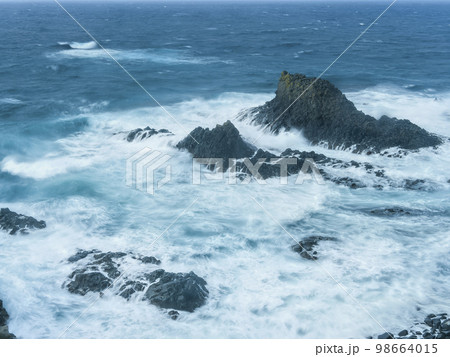 岩礁に打ち寄せる波 98664015