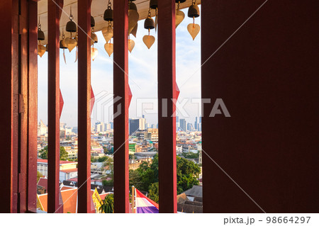 View of Bangkok, Thailand through window of Buddhist temple with bells. View of Bangkok, Thailand through window of Buddhist temple with bells. 98664297