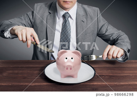 Businessman eating piggy bank. Business concept 98666298