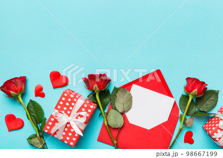 Valentine day composition with Envelope, rose flower and Red heart on table. Top view, flat lay. Holiday concept Valentine day composition with Envelope, rose flower and Red heart on table. Top view, flat lay. Holiday concept 98667199