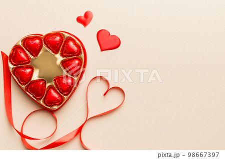 Delicious chocolate pralines in red box for Valentine's Day. Heart shaped box of chocolates top view with copy space 98667397