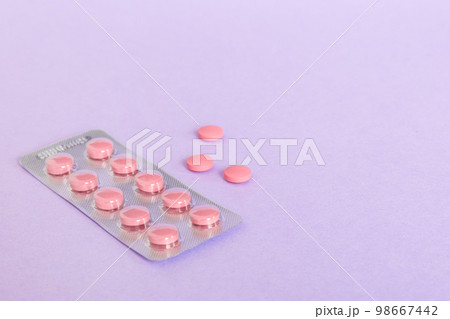 Blister package with Vitamin on color background. Medicine pills on a light background. Medicines and prescription pills flat lay background. pink medical tablets in blister 98667442